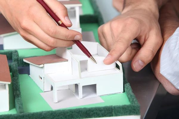Handen wijzen naar een model huis — Stockfoto