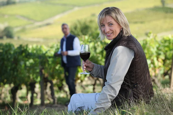 Paar mit einem Glas Wein im Weinberg — Stockfoto