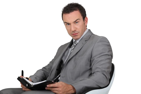 Man in suit writing in diary — Stock Photo, Image