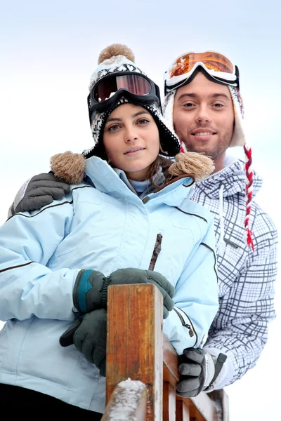 Couple stood in front of skiing holiday accommodation — Stock Photo, Image