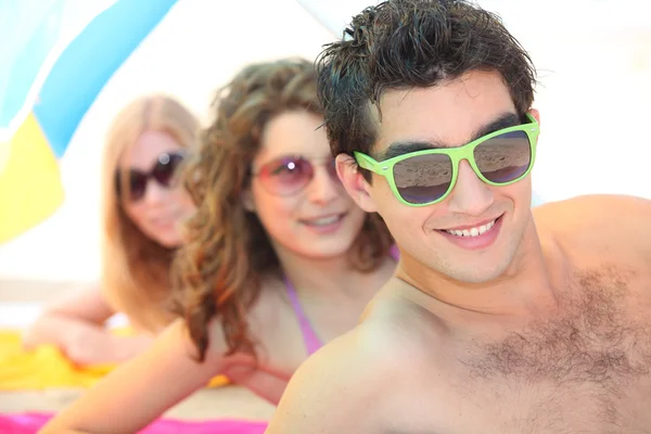 Jeunes sur la plage portant des lunettes de soleil — Photo