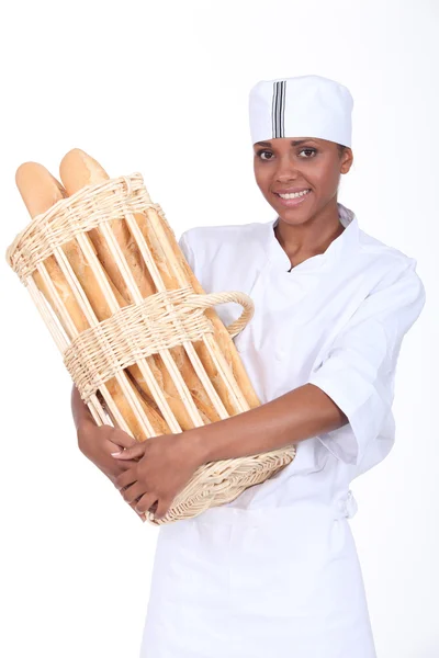 Пекарь держит корзину хлеба — стоковое фото