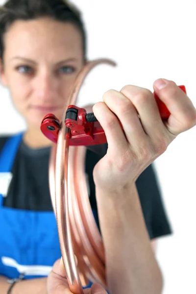 Tradeswoman inserir um tubo de cobre em uma braçadeira — Fotografia de Stock
