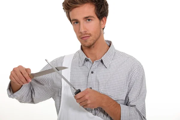 Männlicher Koch schärft Messer — Stockfoto