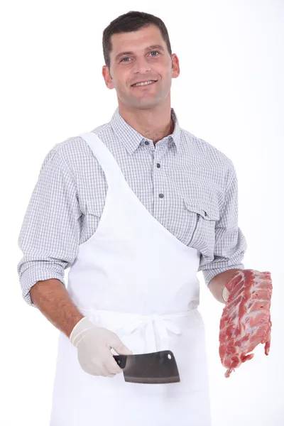 A butcher taking a chopper and pork ribs — Stock Photo, Image