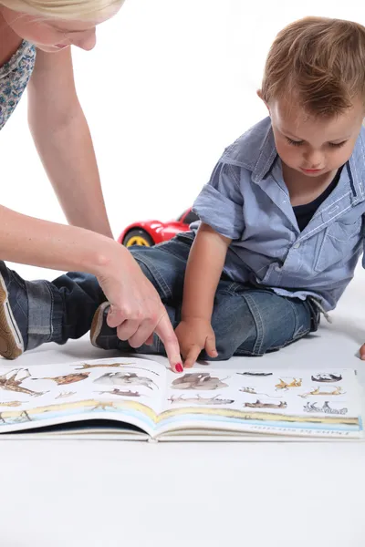 Mutter und Kind schauen sich ein Buch an — Stockfoto