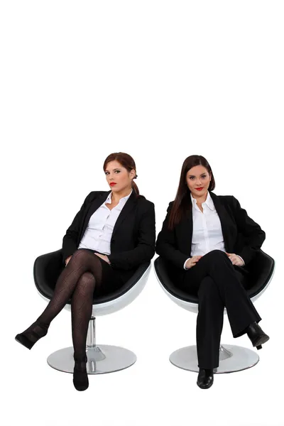 Affärskvinnor som sitter sida vid sida — Stockfoto