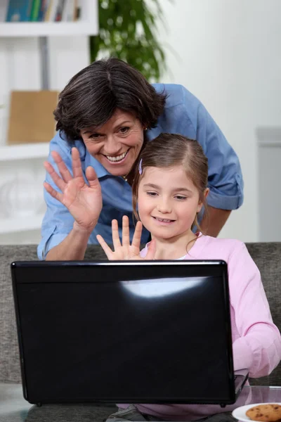 Madre e figlia che parlano con qualcuno su Internet — Foto Stock