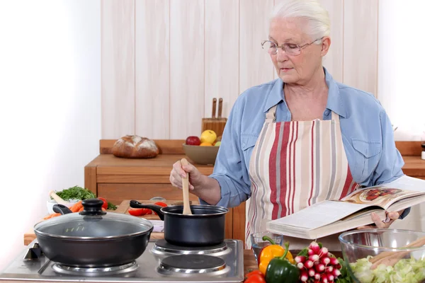 Yaşlı kadın yemek yapıyor. — Stok fotoğraf