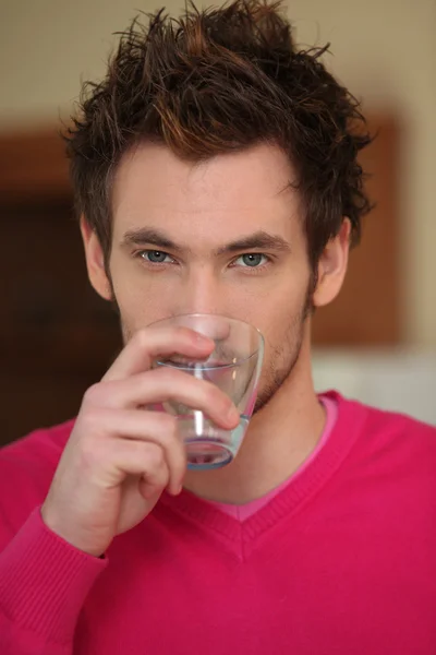 Człowiek od niechcenia picia szklankę wody — Zdjęcie stockowe