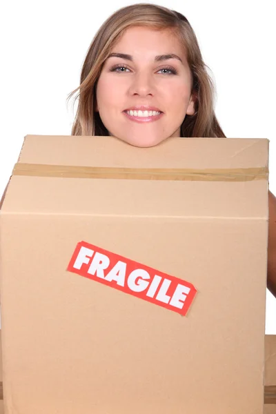 Head of blond girl leaning on moving cardboard — Stock Photo, Image