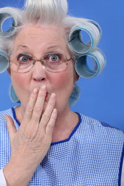 Förvånad gammal kvinna med håret i rullarna — Stockfoto