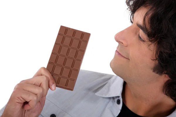 Homme regardant la barre de chocolat — Photo