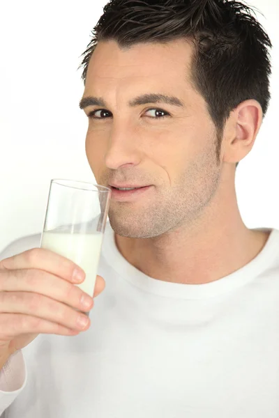 Junger Mann mit einem Glas Milch — Stockfoto