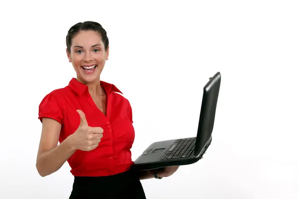 Молодая женщина держит ноутбук и делает большой палец вверх знак — стоковое фото