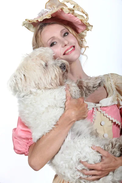 Mujer en traje de dama sosteniendo un perro —  Fotos de Stock