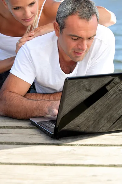 Man lying with a woman behind computer — Stock Photo, Image