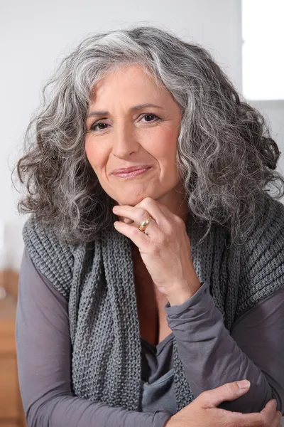 Femme aux cheveux gris touchant le menton — Photo