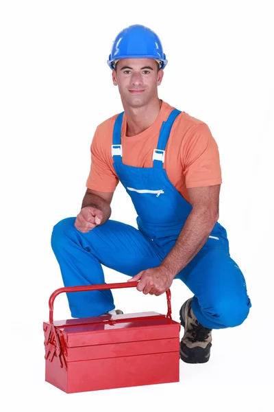 Craftsman squatting with toolbox — Stock Photo, Image