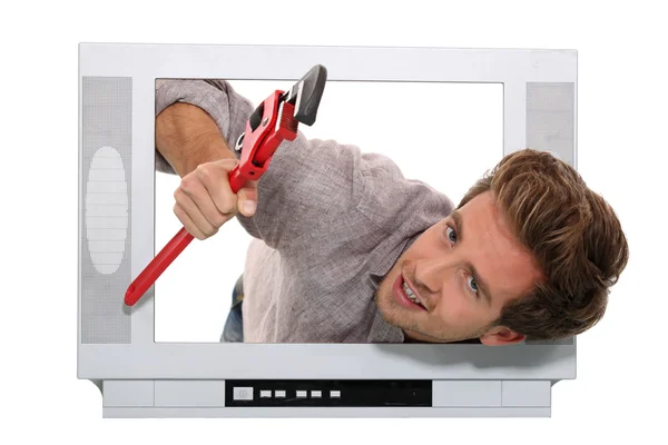 Man met moersleutel binnen televisie — Stockfoto