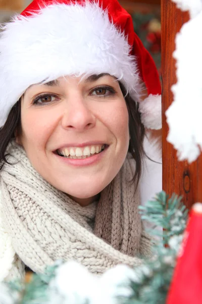 Donna che risponde alla porta con cappello festivo — Foto Stock