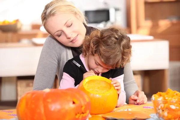 Mamma och dotter carving en pumpa — Stockfoto