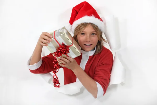 Jonge santa claus houden een geschenk — Stockfoto