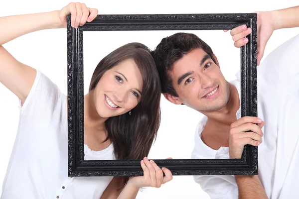 Couple behind black frame — Stock Photo, Image
