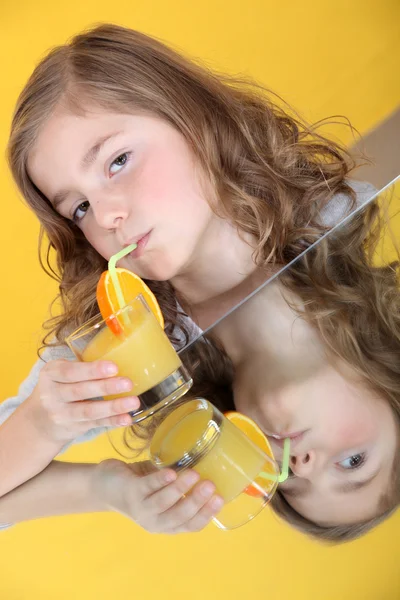 Młoda dziewczyna picie szklanki soku pomarańczowego — Zdjęcie stockowe