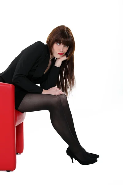 Sexy Frau in Strümpfen sitzt in einem Stuhl — Stockfoto