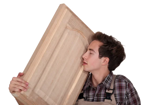 Uomo nuzzling un pezzo di legno artigianale — Foto Stock