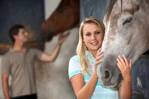 Молодая женщина гладит свою лошадь — стоковое фото
