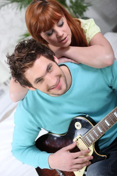 Hombre impresionando chica tocando la guitarra — Foto de Stock