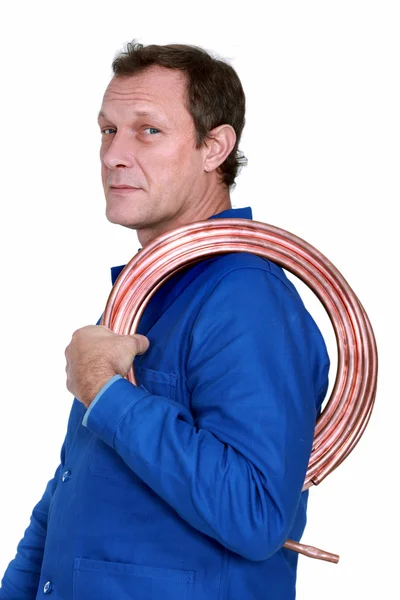 Encanador com uma bobina de tubo de cobre — Fotografia de Stock