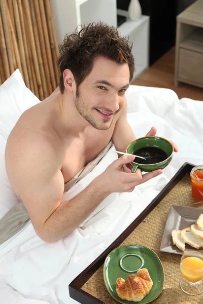 침대에서 아침을 먹는 남자 — 스톡 사진