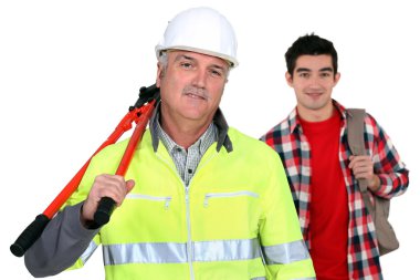 Experienced tradesman posing with his new apprentice clipart