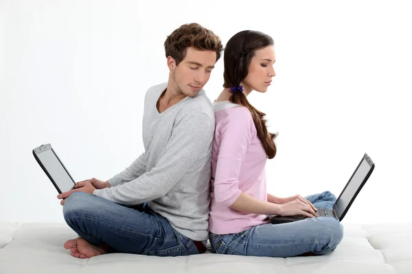 Portrait de charmant jeune couple dos à dos avec ordinateur portable — Photo