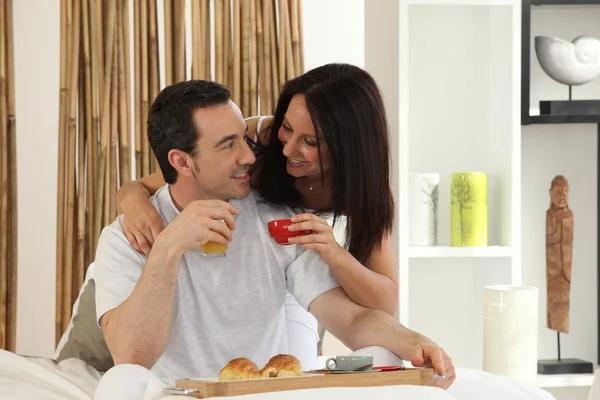 Ευτυχισμένο ζευγάρι τρώει πρωινό στο κρεβάτι — Φωτογραφία Αρχείου