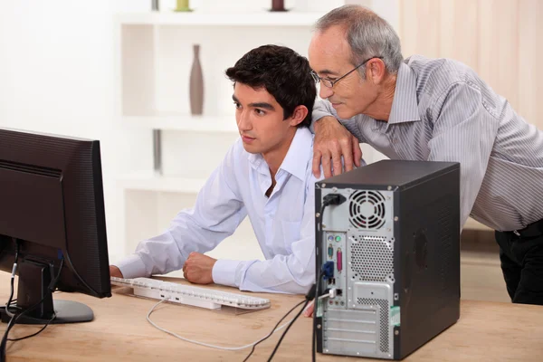 Farfar och sonson tittar på datorn — Stockfoto