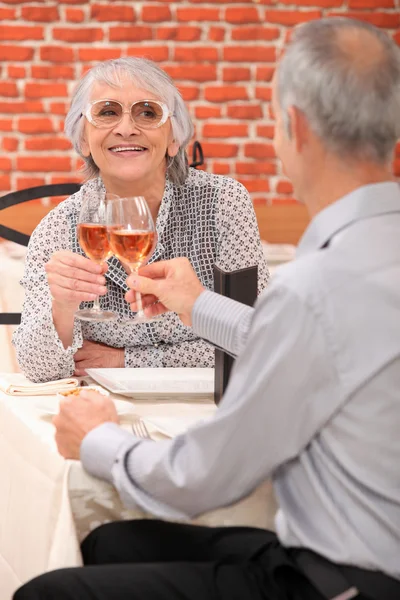 Mature couple toasting avec du vin rose — Photo