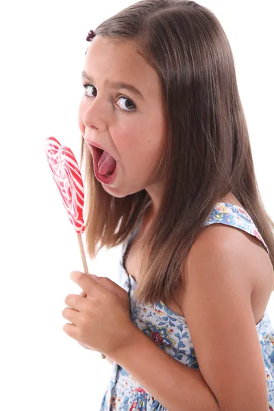 Chica comiendo corazón lolly pop —  Fotos de Stock