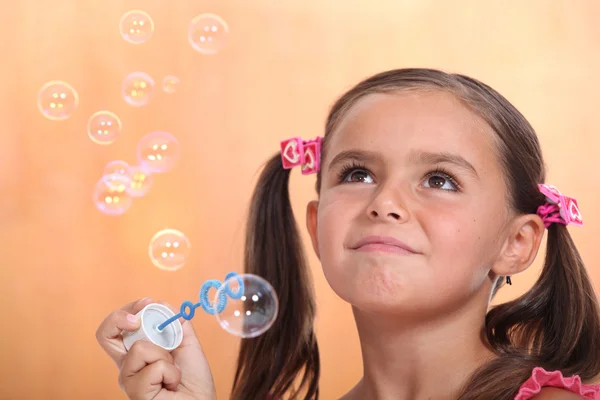 Дівчина дме бульбашки — стокове фото