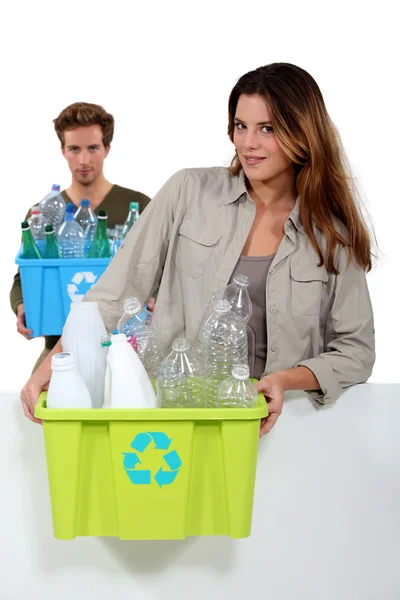 Giovane coppia che trasporta bottiglie di plastica — Foto Stock