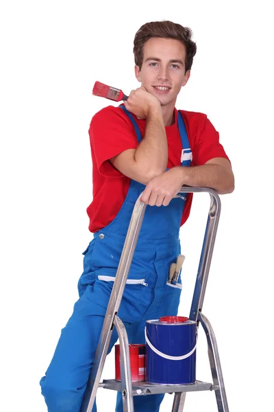 Young man with tin of red painting and brush — Stock Photo, Image