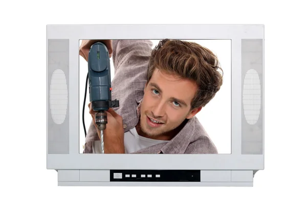 텔레비전 안에 드릴링 하는 남자 — 스톡 사진