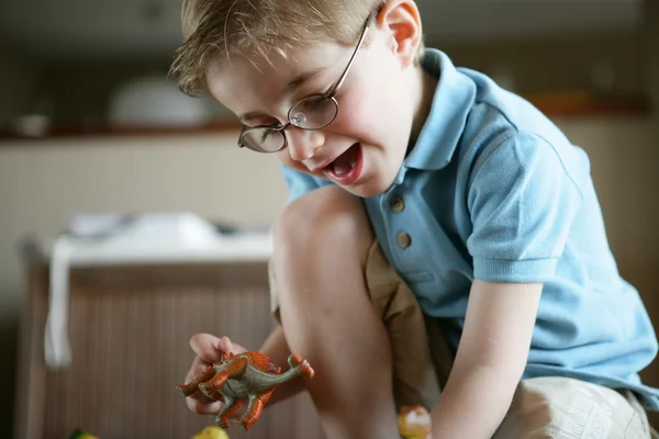 Malý chlapec hraje s hračku dinosaura — Stock fotografie