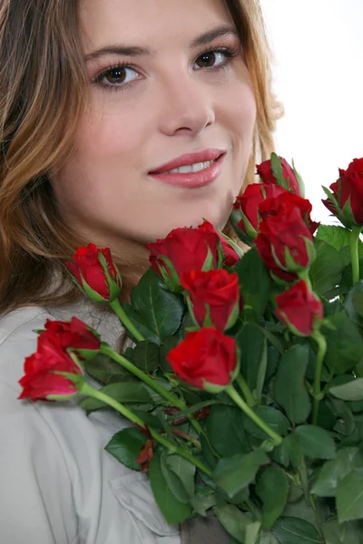 Νεαρή γυναίκα με μια δέσμη των κόκκινων τριαντάφυλλων — Φωτογραφία Αρχείου