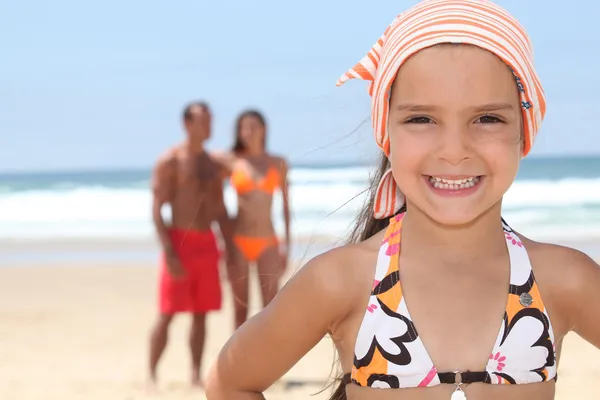 Giovane ragazza in spiaggia con i suoi genitori — Foto Stock