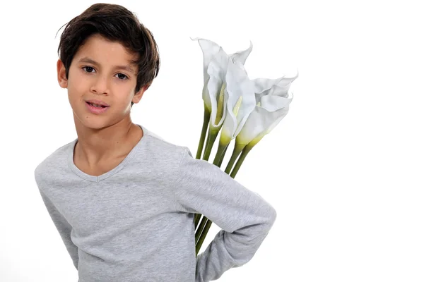 Little boy holding bunch of flowers behind his back — Stock Photo, Image