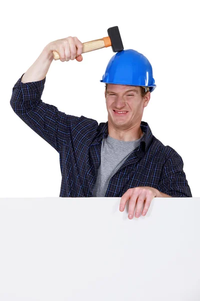 Arbeiter schlägt sich mit Hammer auf den Kopf — Stockfoto